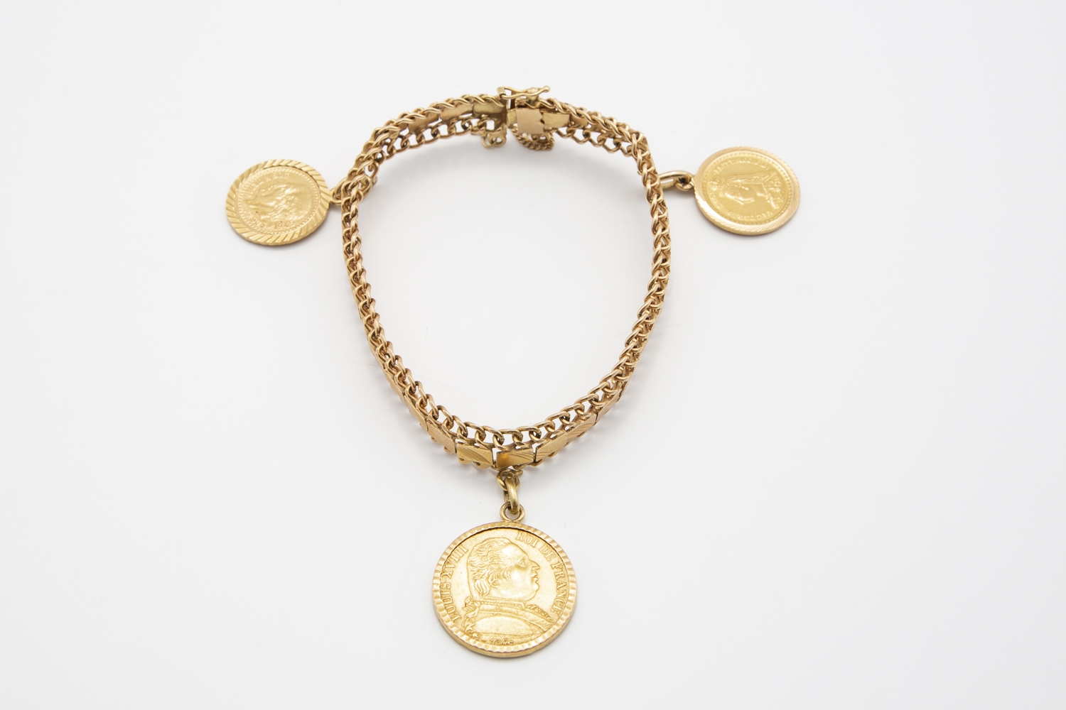 12 - Bracelet en or jaune 18K 750° avec 3 pièces en breloque. Adjugé 900€