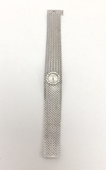 30-1 OMEGA Bracelet montre de dame en or gris la lunette sertie de diamants. Adjugé 1850€