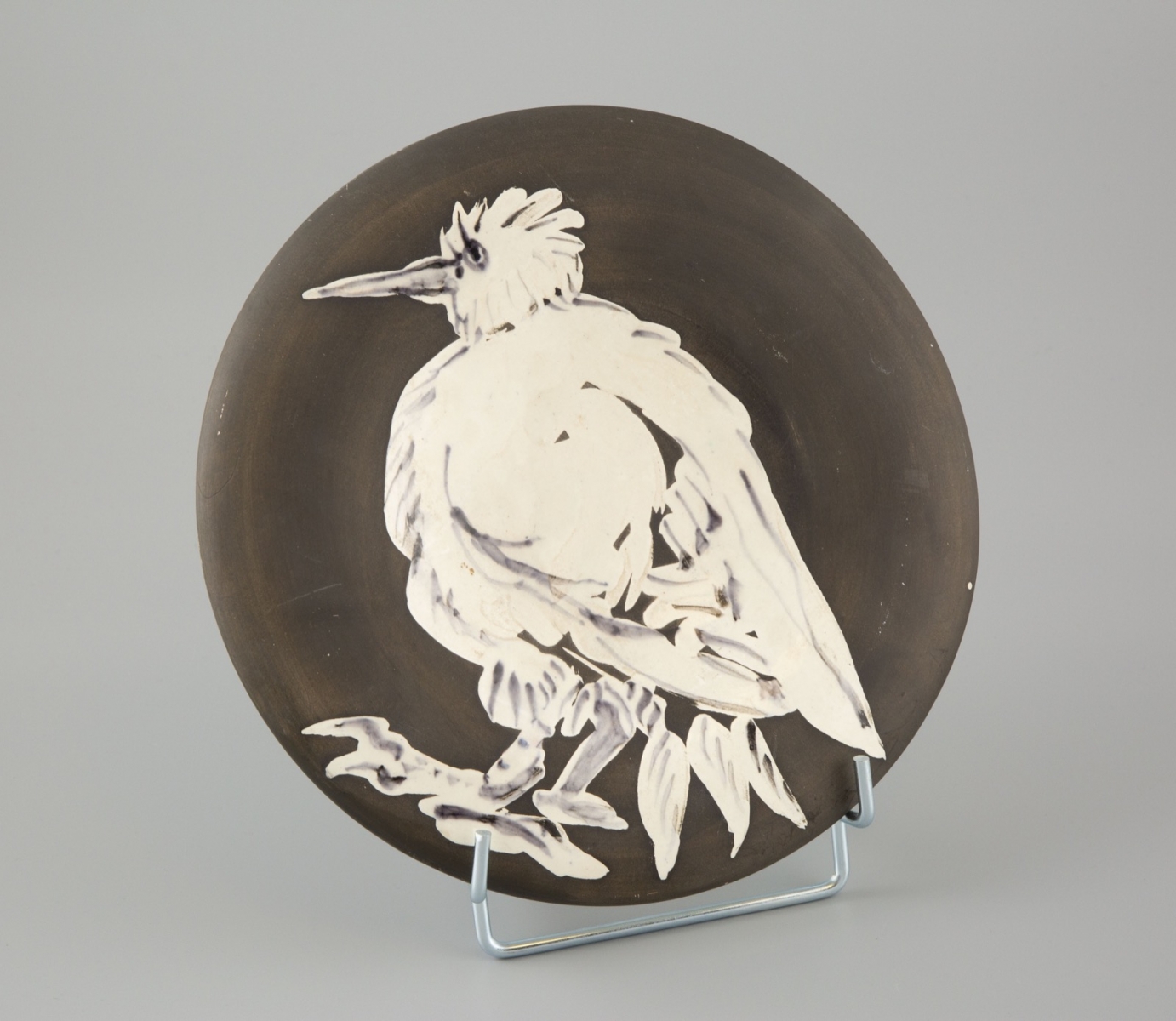 62- Pablo Picasso-Madoura. Oiseau n°76. Assiette en terre de faience blanche, l'engobe noire. D.25cm. Adjugé 3300€