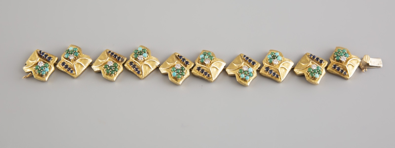 Lot 40 : Bracelet articulé en or jaune 18K serti de turquoises, pierres bleues et petits diamants. Poids brut 38,9g. Adjugé : 2063€
